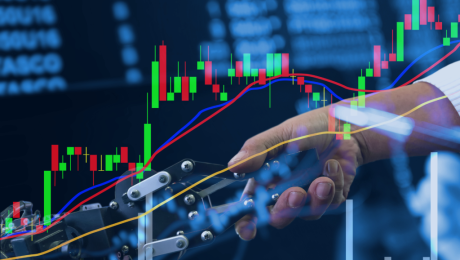 Ludzka dłoń ściska mechaniczną dłoń. Na grafikę nałożony jest wykres giełdy.